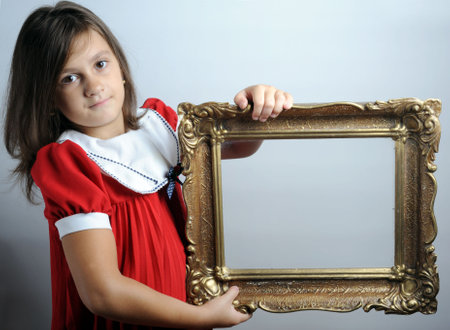 Portrait of a girl holding an empty picture frameの写真素材