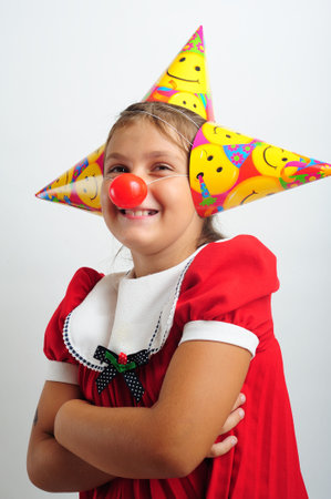 Little girl with party horn and clown nosesの写真素材