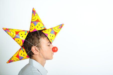 Young boy with party horn and clown nosesの写真素材
