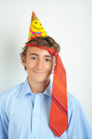 Young boy with party horn and tie holded on his headの写真素材