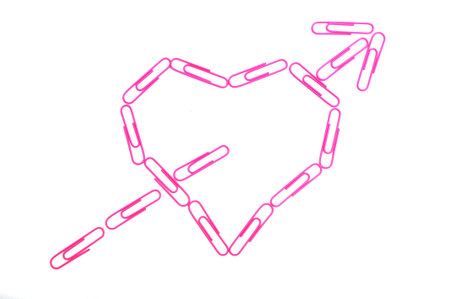Pink paper clips in heart shpe on white backgroundの写真素材