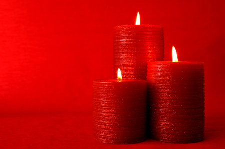 Three burning red candles - selective focus on foregroundの写真素材
