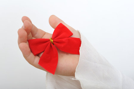 Close up of a red ribbon in a child handの写真素材