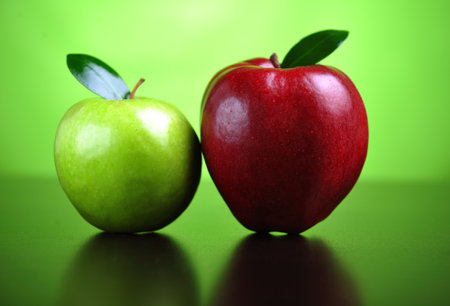 A green and a red apple on a tableの写真素材