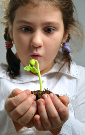 Girl holding a bud and earth in handsの写真素材