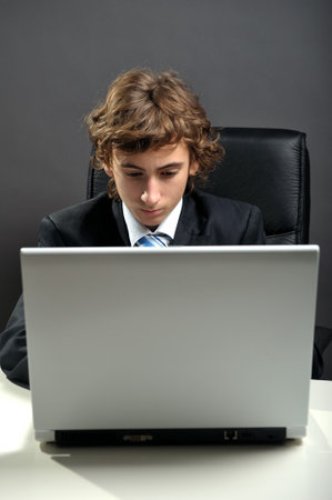 Young businessman at desk using computer laptopの写真素材