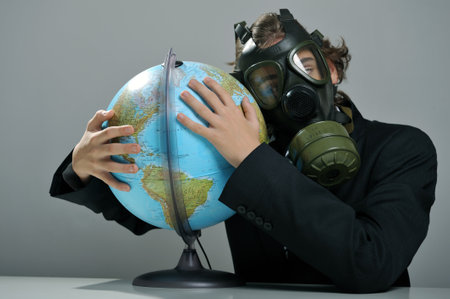 Businessman with gas mask on face holding earth globe