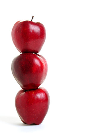 Stack of three red apple in equilibrium on white backgroundの写真素材