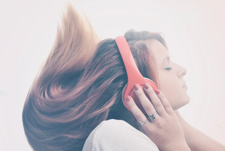 Girl is listen to the music on headphonesの写真素材