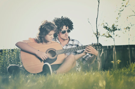 Boy teaches girl to play guitar