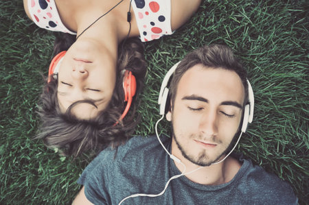 Couple listening to music on headphonesの写真素材