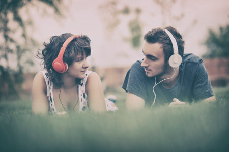 Boy and girl  listening to music on headphonesの写真素材