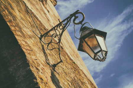Old street lantern on a stone wall in the Fortress Sighisoara in Romania, Transylvaniaの写真素材