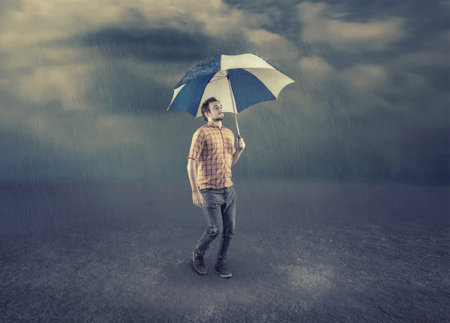 Man hold an umbrella while walk on a rainy day.の写真素材