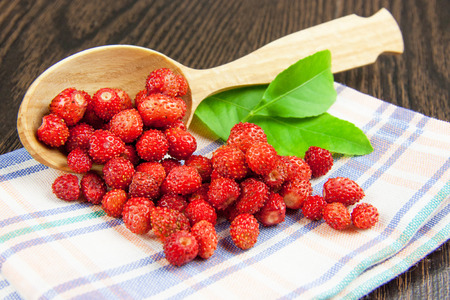 juicy strawberries on a wooden spoon on a napkinの写真素材