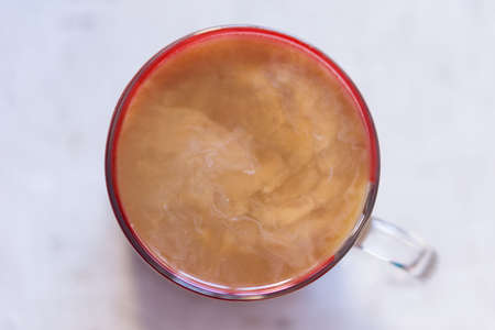 Coffee mixed with milk, top view on a mug