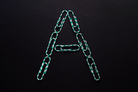 The letter "A", folded from paper clips on a black backgroundの写真素材