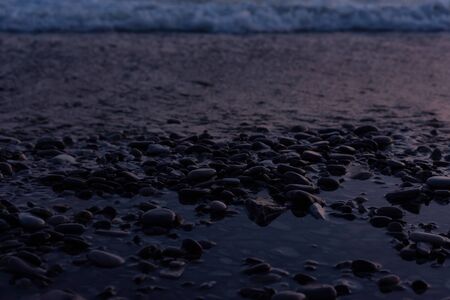 Wet pebbles on the beach during sunset