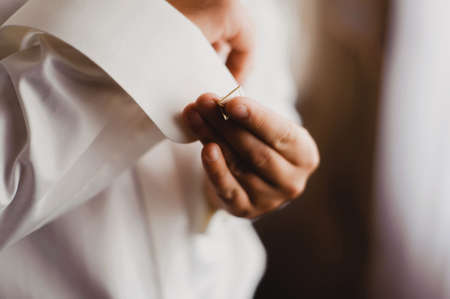 In the picture a man's hand. He buttons cufflinks, going to the ceremony.の写真素材