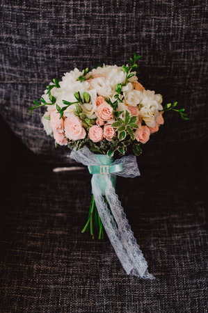 Wedding bouquet stands upright in a chair, black background.の写真素材