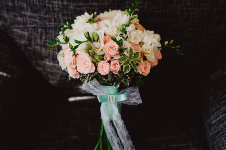 Wedding bouquet stands upright in a chair, black background.の写真素材