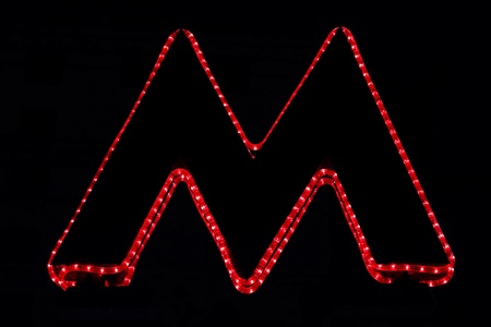A pointer to the entrance to the Moscow metro in the form of letters''M'', made of light cordの写真素材