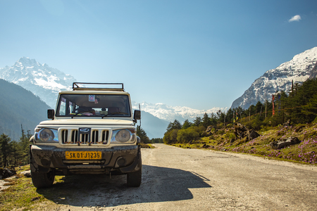 Sikkim, India - April 13, 20, 2013: The Off Road car with snow moutain on background in Sikkim, Indiaのeditorial素材
