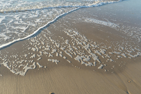 water rolling onto beachの写真素材