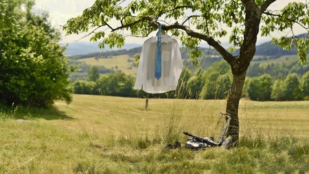 Saxophonist's white shirt with blue tie hang on the treeの写真素材