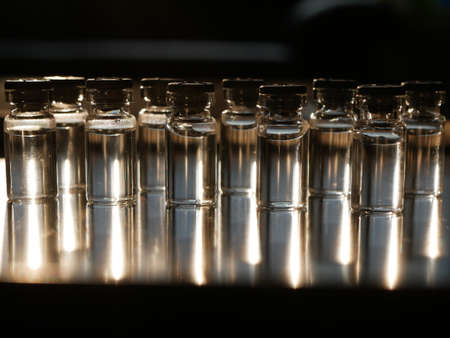Filled vials in dramatic light on a reflecting metal plate