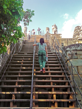 SIEM REAP, CAMBODIA - December 20, 2013 : Visitors at Phnom Bakheng in Angkor. Angkor was inscribed...