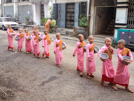 YANGON, MYANMAR - APRIL 17, 2013: Buddhist nuns are walking at the streets of  Yangon in Myanmar (Burma)のeditorial素材