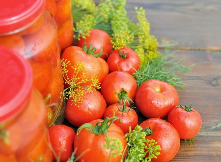 Tomatoes. Canned tomatoes. Glass jars with tomatoes. Vegetables on the table. Vegetable for the winter.の写真素材