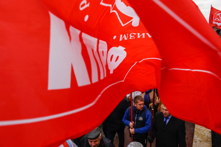 Orel, Russia, November 4, 2017: Unity Day demonstration. Red Communist flag covering people under it and holding flagsのeditorial素材