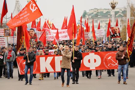 Orel, Russia, November 7, 2017: October Revolution anniversary meeting. Crowd of people marching with red Communist flags, banners, Lenin and Stalin portraits on the streetのeditorial素材