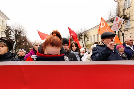 Orel, Russia, November 7, 2017: October Revolution anniversary meeting. Girl hides her face from camera behind red communist bannerのeditorial素材