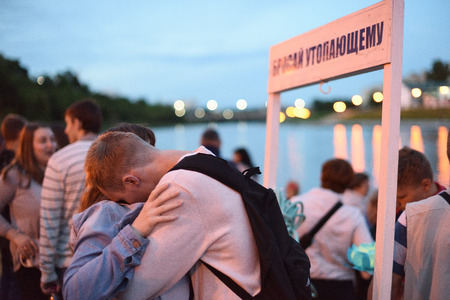 Orel, Russia, July 07, 2017: Night water light fest. Young people hugging at sign Throw to a drowning one at nightのeditorial素材