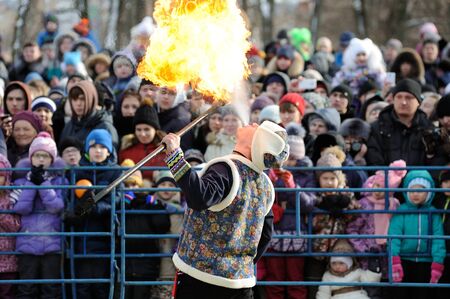 Orel, Russia - February 26, 2017: Maslenitsa fest. Man breathing fire in fire show  and crowd of  peopleのeditorial素材