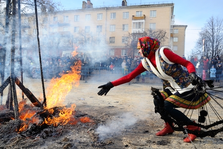Orel, Russia - February 26, 2017: Maslenitsa fest. Girl in Russian dress at bonfire closeupのeditorial素材