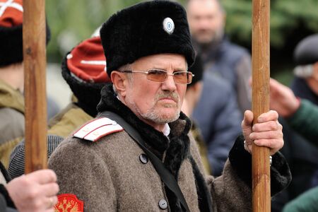 Orel, Russia - October 14, 2016: Ivan the Terrible monument opening ceremony. Grumpy man in cossack uniform holding banner and loking at cameraのeditorial素材