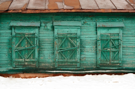 Old poor abandoned country house with three shut windows horizontalの写真素材