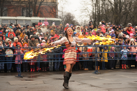 Orel, Russia - March 13, 2016: Maslenitsa, Pancake festival. Fire dancer girl in Russian clothes performing for crowd horizontalのeditorial素材