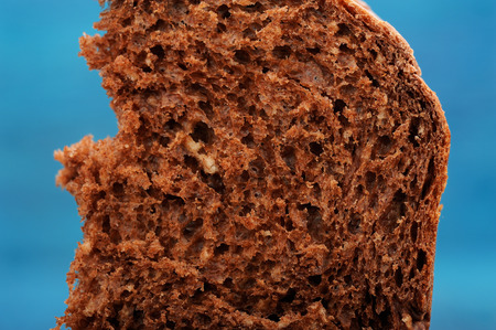 Cut of homemade chocolate panettone on blue background closeup