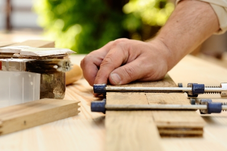 Carpenter hands at work with clamp closeupの写真素材