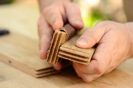 Carpenter hands at work with wooden boards closeup
