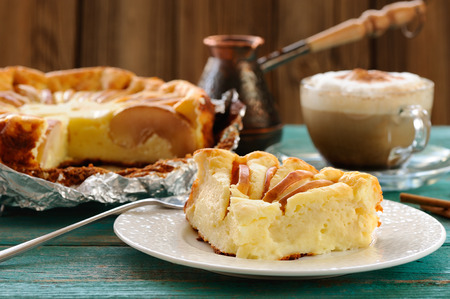 Syrnik, quark pie with apples served with Vienna coffee on old wooden table horizontalの写真素材