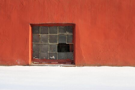 Broken glass brick window in red plastered wall copyspace horizontal