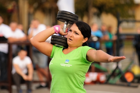 Orel, Russia, September 5, 2015: Woman powerlifter lifts heavy dumbell with one hand in competition closeupのeditorial素材