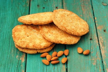 Yummy homemade almond cookies with whole almonds on turquoise shabby background horizontalの写真素材