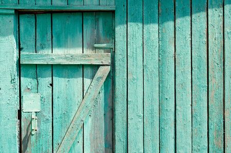 Green wooden door with part of fence copyspace horizontalの写真素材
